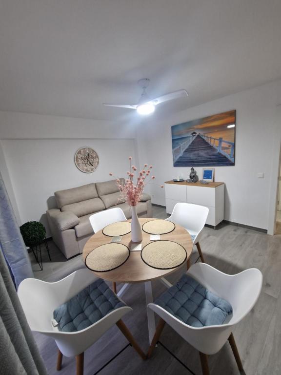Una sala de estar con una mesa y sillas y un sofá. en Piso vacacional, en Calpe