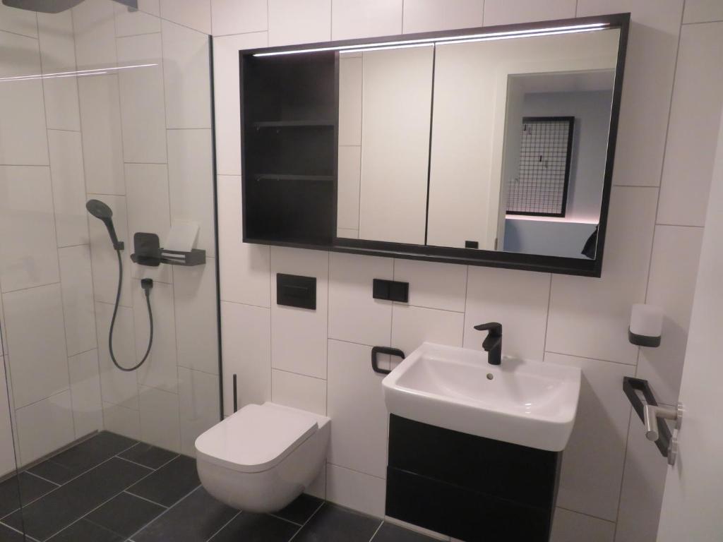 uma casa de banho com um WC, um lavatório e um espelho. em Hotelapartment Meerlust em Cuxhaven