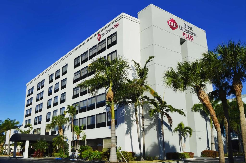 een kantoorgebouw met palmbomen ervoor bij Best Western Plus Ft Lauderdale Hollywood Airport Hotel in Hollywood