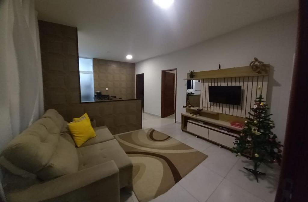 uma sala de estar com um sofá e uma árvore de Natal em Apartamento para até 4 pessoas em Garanhuns-PE em Garanhuns