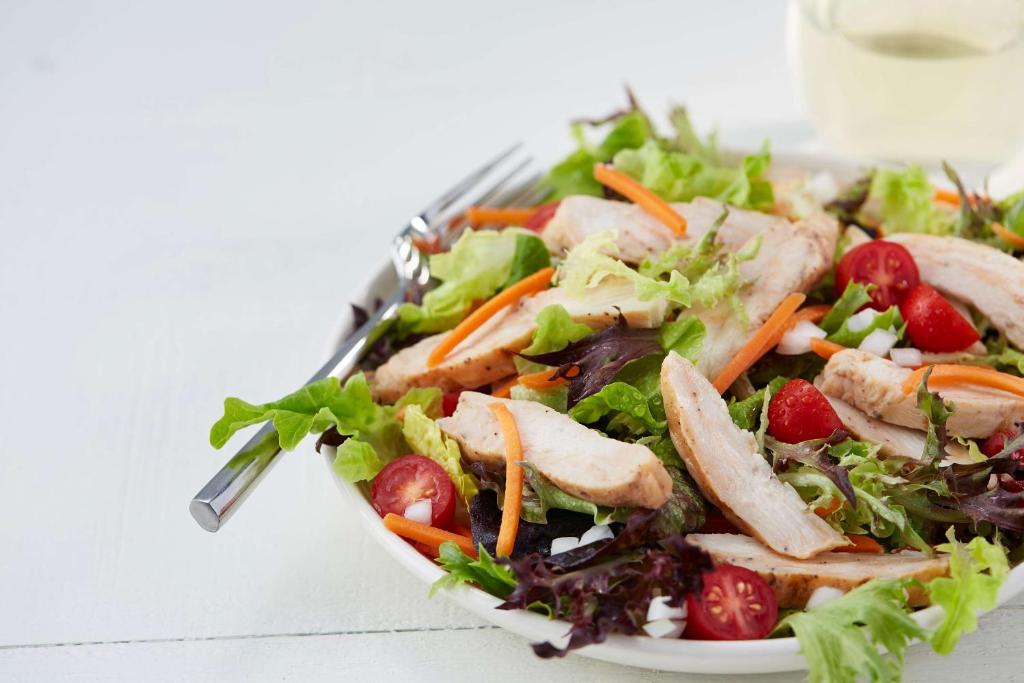 a salad with chicken and vegetables on a plate at Drury Inn & Suites Lafayette LA in Lafayette