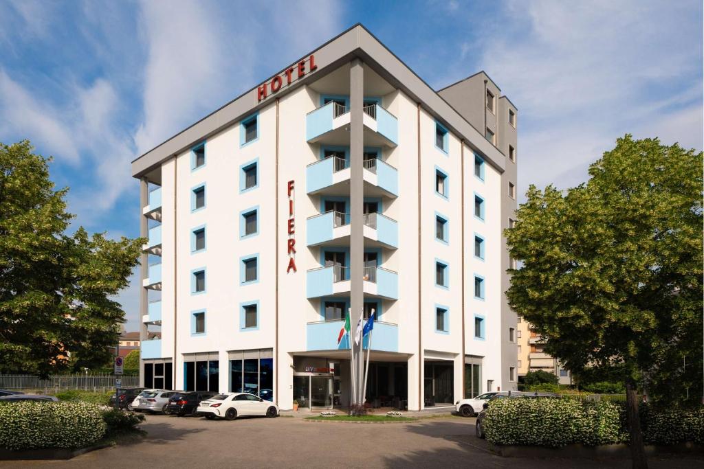 een hotelgebouw met auto's geparkeerd op een parkeerplaats bij Best Western Hotel Fiera Verona in Verona