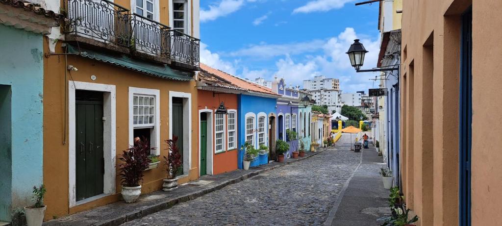 una calle vacía con edificios coloridos y una luz de la calle en Apto com Arte no Pelourinho en Salvador