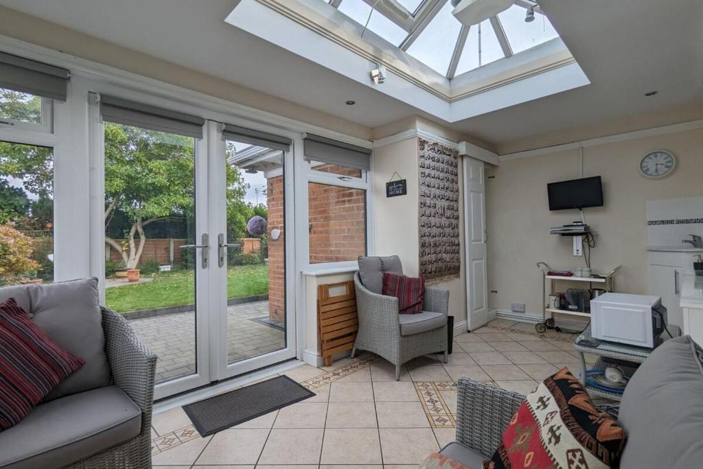 a living room with a conservatory with a glass ceiling at Cozy Barnhill Annex in Manchester