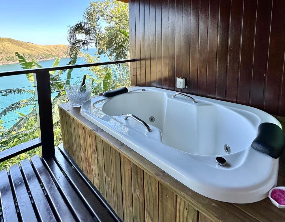 eine Badewanne auf einer Terrasse mit Blick auf das Wasser in der Unterkunft Ilha de Toque Toque Eco Boutique Hotel & Spa in Toque Toque Grande