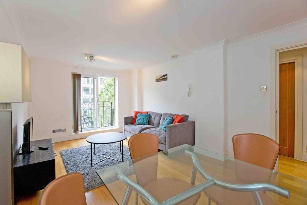 ein Wohnzimmer mit einem Glastisch und einem Sofa in der Unterkunft Globe View St Pauls London in London