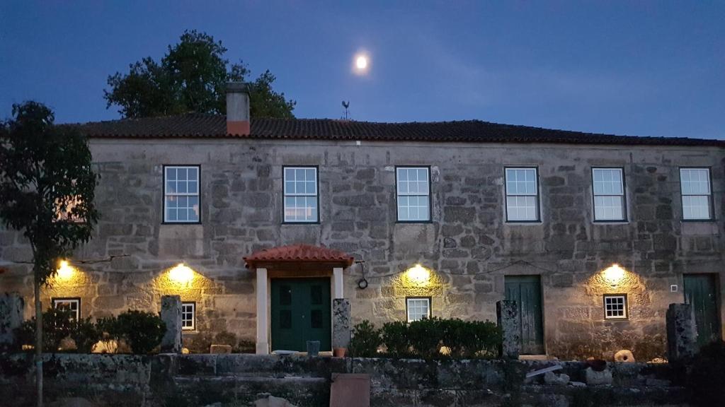 uma casa de pedra com luzes à frente em Solar dos Pedrosos em Vila Chã