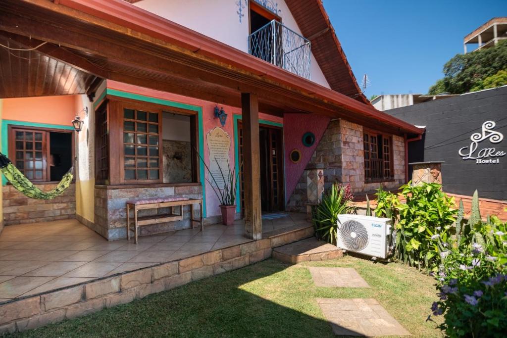 een huis met een veranda en een ventilator bij Hostel LARes in Brumadinho