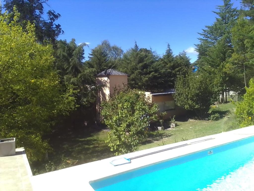 una casa con piscina y árboles en Las Moras en Villa Giardino