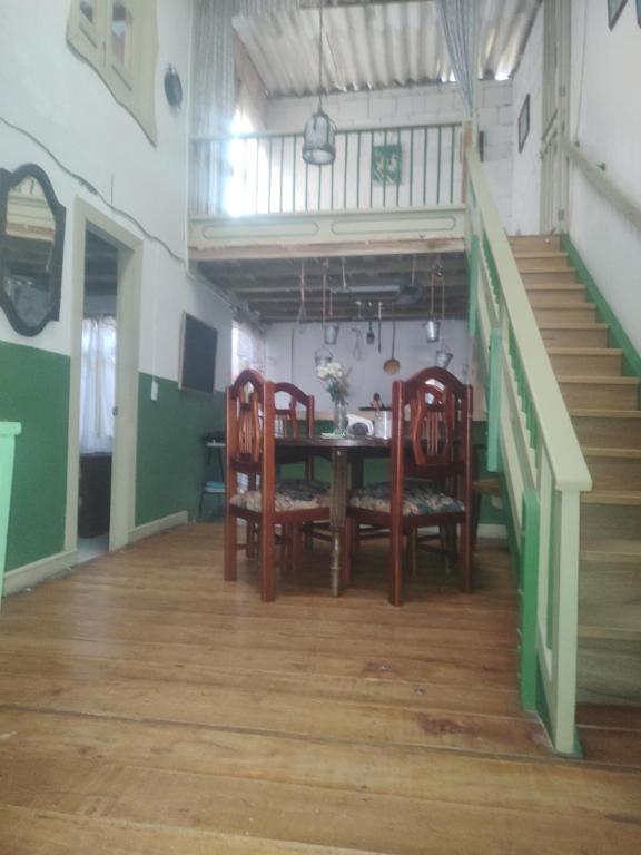comedor con mesa, sillas y escaleras en HOSPEDAJE OK en Salento
