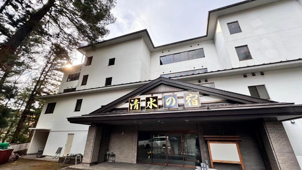um edifício com uma placa na frente dele em Tabist Nikkokinugawa Onsen Kiyomizu no Yado em Nikko