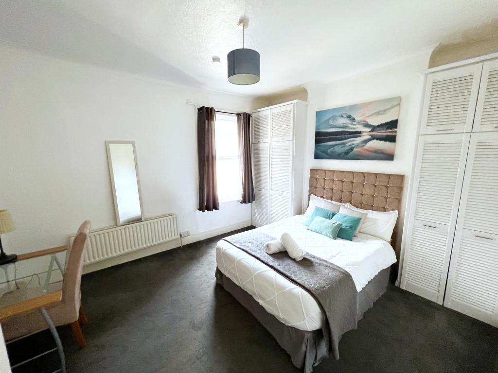 Newly Refurbished 2 Bedroom Flat - Long stays AVL في Norbury: غرفة نوم فيها سرير ومكتب