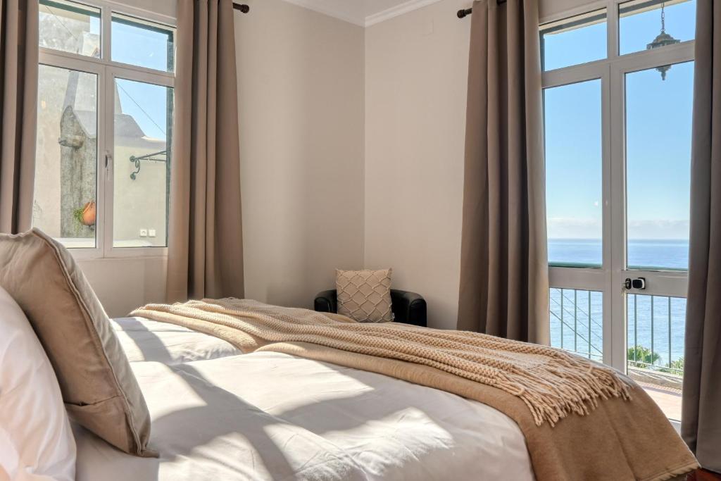 a bedroom with a bed with a view of the ocean at Freitas Paradise, a Home in Madeira in Ponta do Sol