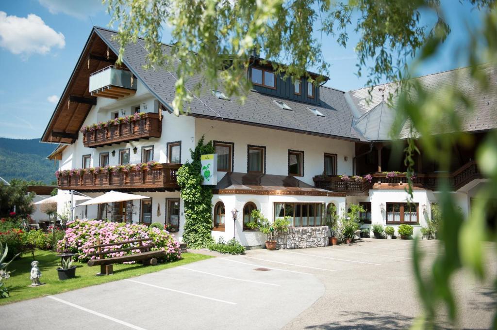 a building with a tennis court in front of it at Pension Irlingerhof in Mondsee