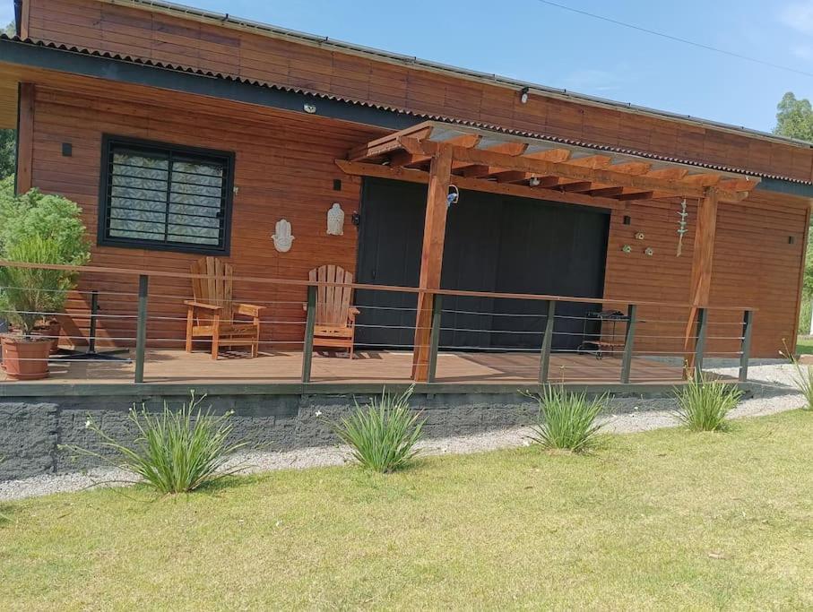 a wooden cabin with chairs and a porch at Casinha na serra para até 4 pessoas in Nova Petrópolis