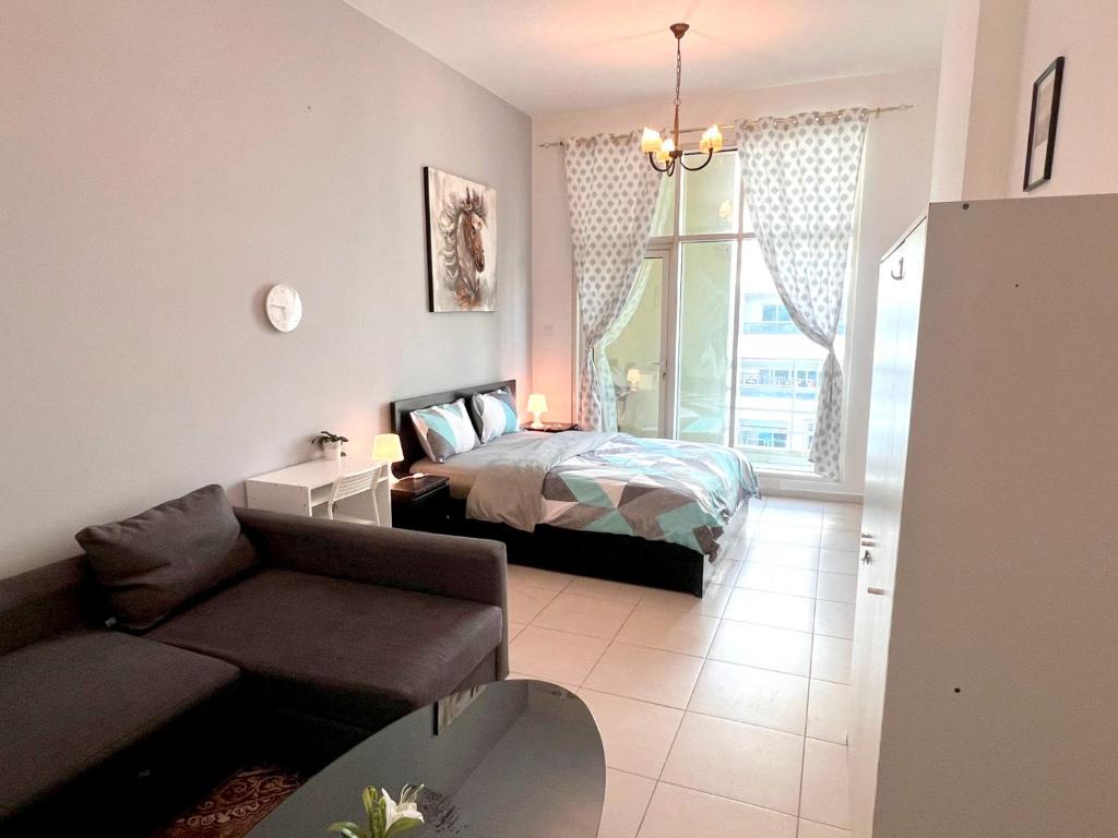 - une chambre avec un lit, un canapé et une fenêtre dans l'établissement Huge Room in Al Barsha 1 Near Mashreq Metro, à Dubaï