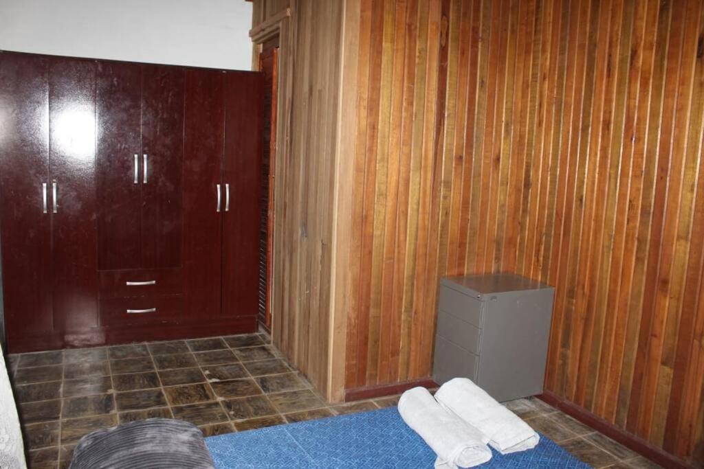 baño con paredes revestidas de madera y habitación con armario en Casa Luka, en Turrialba