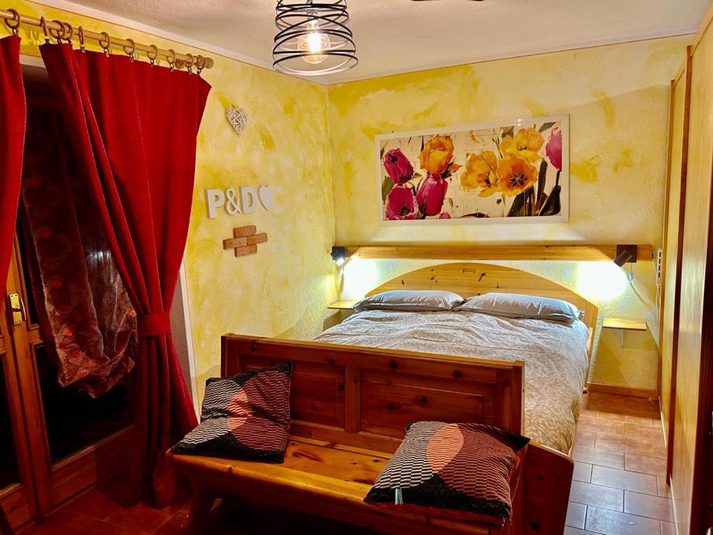 a bedroom with a wooden bed and red curtains at Casa del Lago in Valtournenche