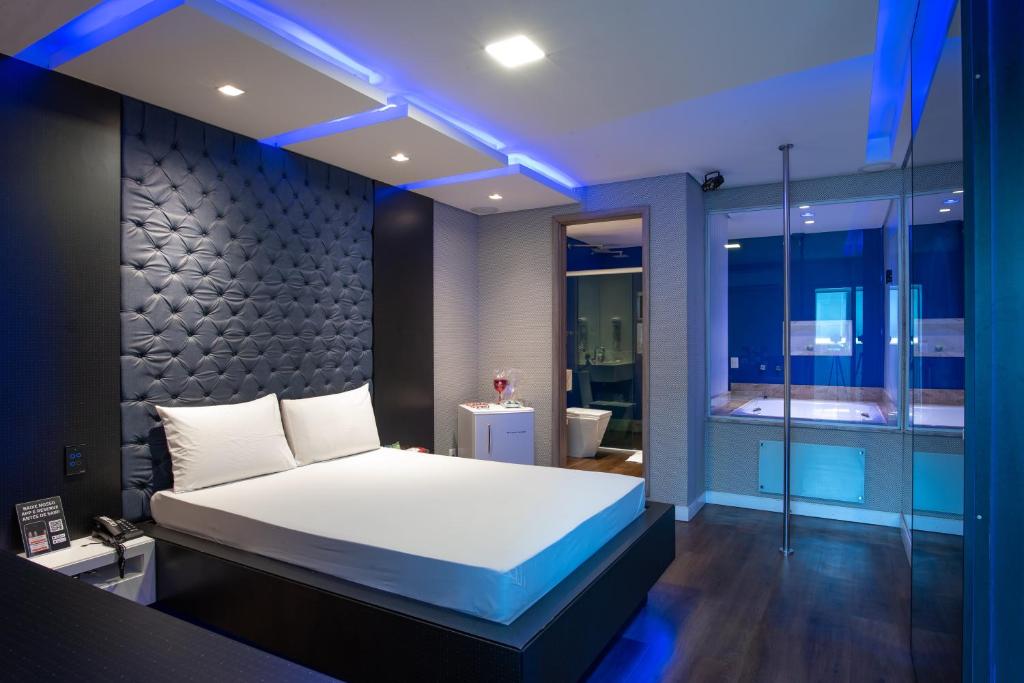 een slaapkamer met een bed en een badkamer met een bad bij Motel Fantasy 3 (Adult Only) in Belo Horizonte