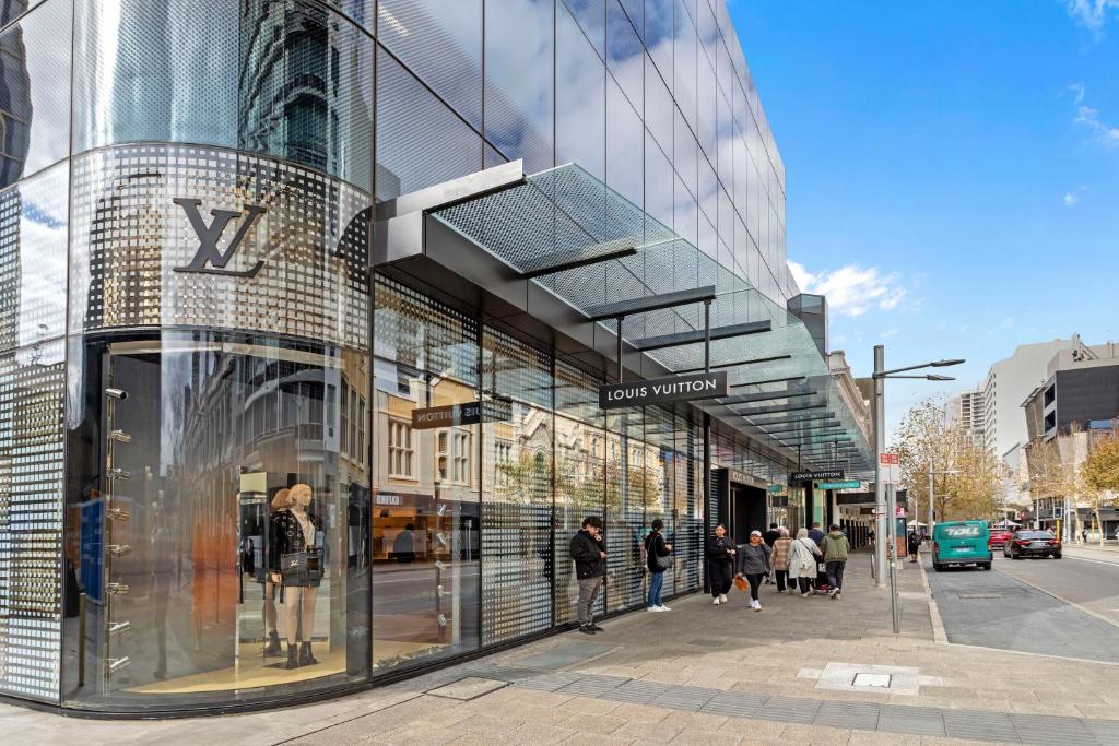 un edificio de cristal con gente caminando delante de él en Downtown Perth Studio On Murray Street, en Perth