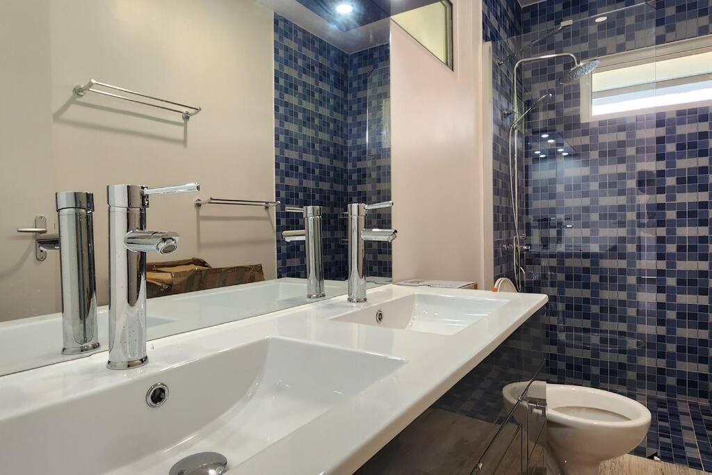 uma casa de banho com 2 lavatórios e um WC em Âpara Feti'a - Mirimiri Lodge em Tevaitoa