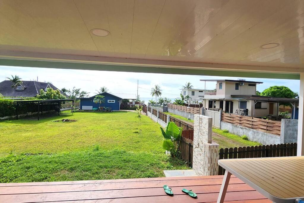 einen Balkon mit Blick auf einen Hof mit Häusern in der Unterkunft Painapoo - Mirimiri Lodge in Tevaitoa