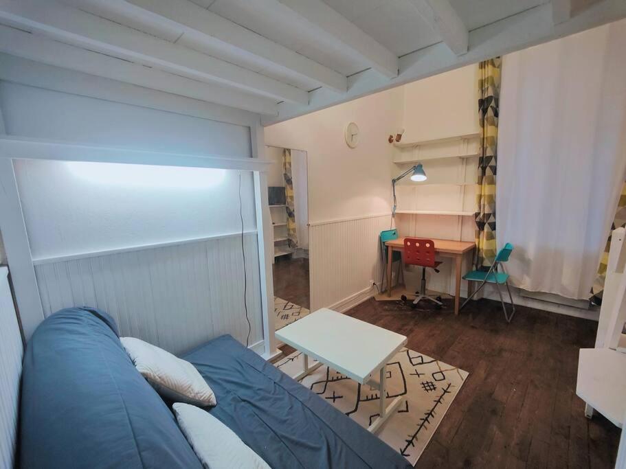 a living room with a blue couch and a table at appartement parc des expositions/tour eiffel in Paris