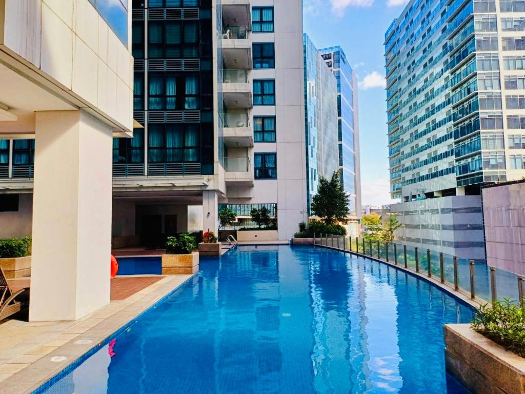 a swimming pool in a building with tall buildings at Deluxe Queen 1BR Luxury Suite 11 - Pool, City View in Manila