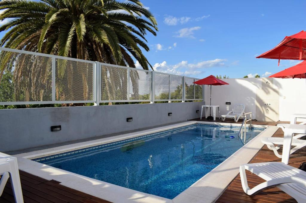 a swimming pool with chairs and umbrellas on a building at Catalina Hotel in Colón