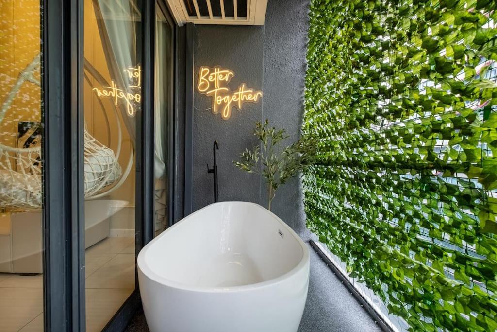 a white bath tub in a room with a green wall at Romantic Couple Bath Tub 6km to KLCC 网红浴缸小红书爆款 in Kuala Lumpur