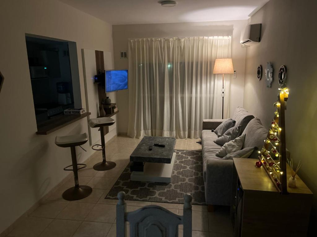 ein Wohnzimmer mit Sofa und Weihnachtsbaum in der Unterkunft DEPARTAMENTO CENTRICO in Dolores