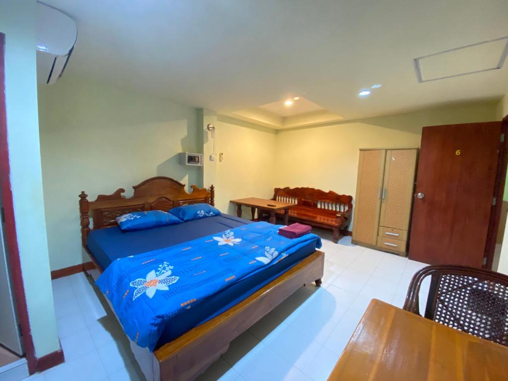 a bedroom with a bed with a blue comforter at Bambus Motel in Jomtien Beach