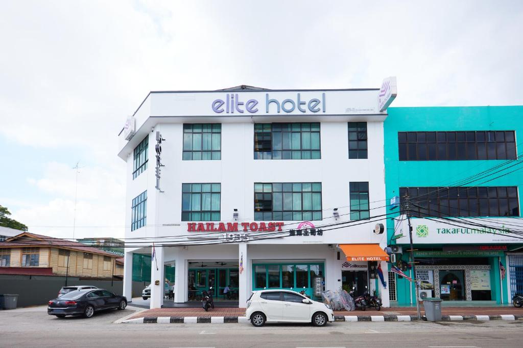 a hotel with cars parked in front of it at Elite Hotel in Muar