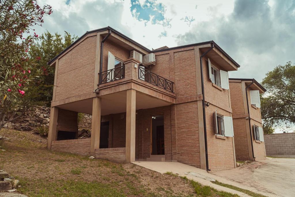 een bakstenen huis met een balkon erop bij Duplex Madrid in Alta Gracia