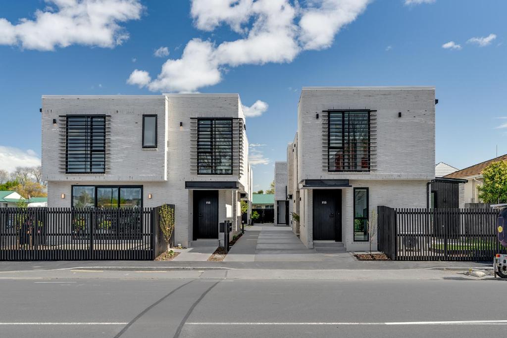a white building with black shutters on a street at Brand new 3 Bed 3 Bath in Christchurch