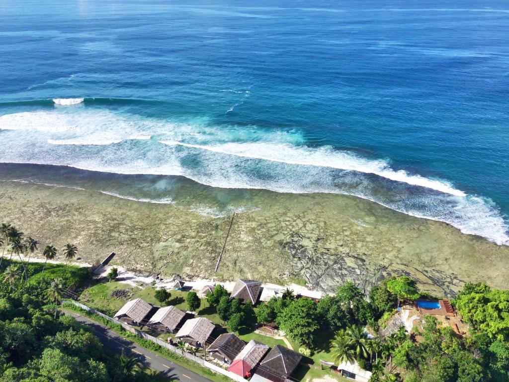 an aerial view of a beach with houses and the ocean at BatuRundung Surf Resort in Naibos