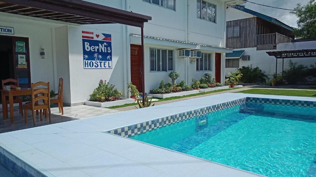 a swimming pool in front of a building at Bernis Hostel in Moalboal