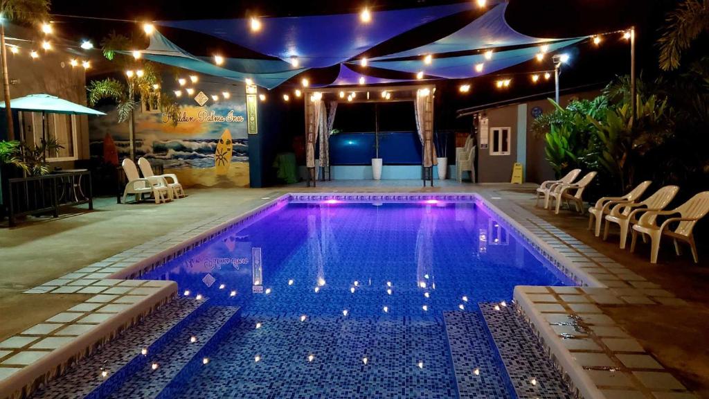 a swimming pool at night with lights and a tent at Hidden Palms Inn/Resort La Union in San Juan