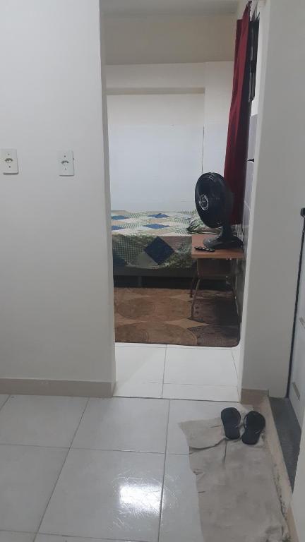 um quarto com uma porta aberta para um quarto com um espelho em Kitinete perto da Praia em Vila Velha