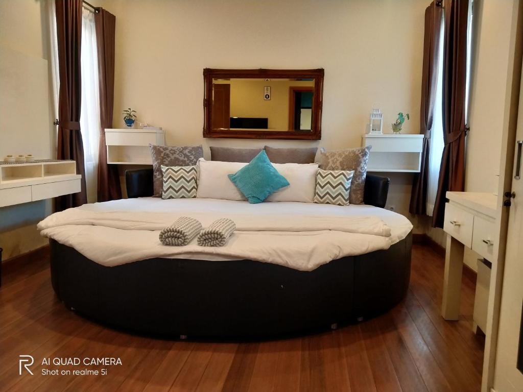 a large bed in a room with a mirror at Vimala Hills FARLA Villa - 3BR in Gadok 1