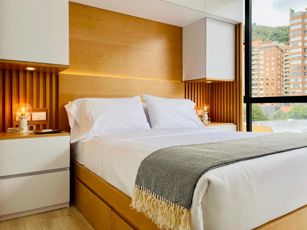 een slaapkamer met een groot bed en een raam bij Charming loft in the heart of Santa Barbara in Bogota
