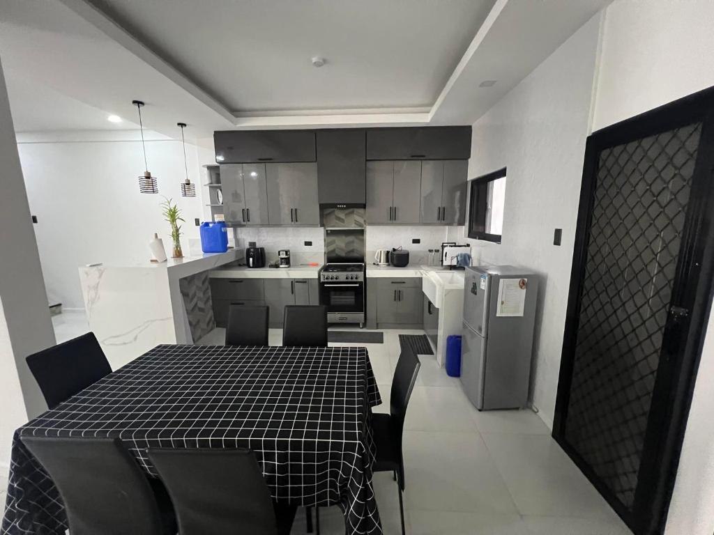 a kitchen with a black and white table and chairs at Cozy Haven in Manila