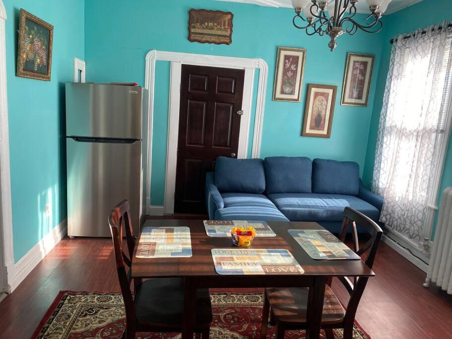 ein blaues Wohnzimmer mit einem Tisch und einem blauen Sofa in der Unterkunft Classic King Suite Apartment in Schenectady