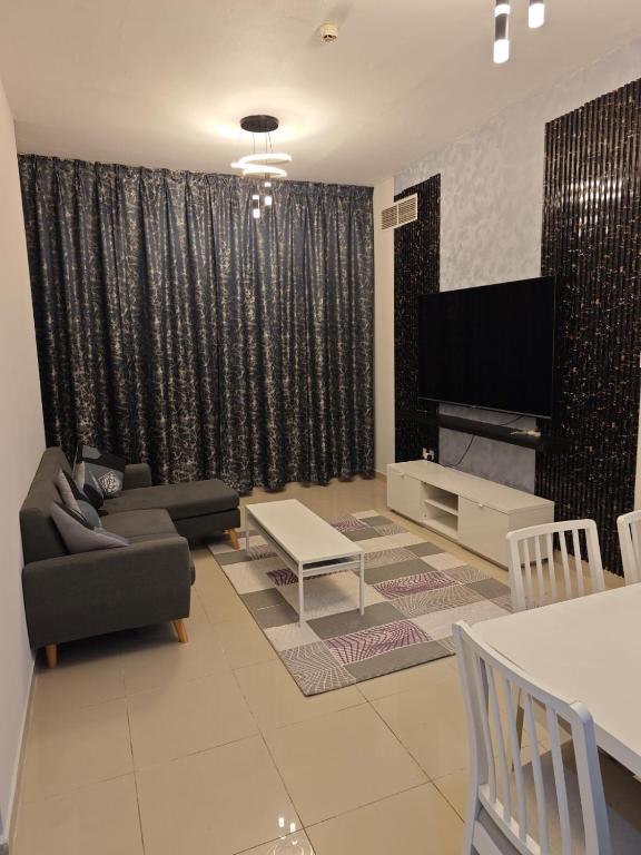 a living room with a couch and a flat screen tv at Ajman preal modren 1 bed room in Ajman 