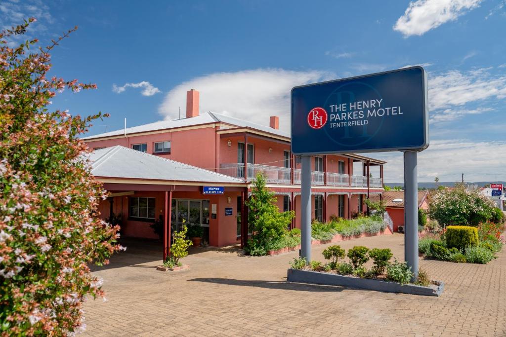 ein Schild vor einem großen rosa Gebäude in der Unterkunft The Henry Parkes Tenterfield in Tenterfield