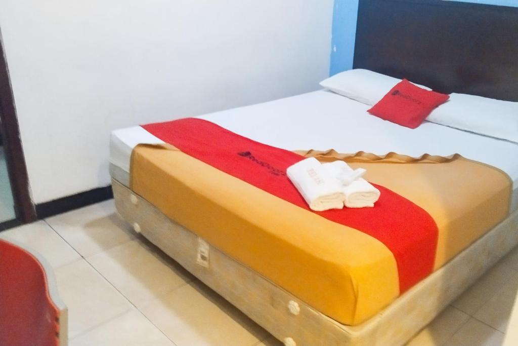 uma cama num quarto com duas toalhas em RedDoorz near Living Plaza Palembang em Palimbão