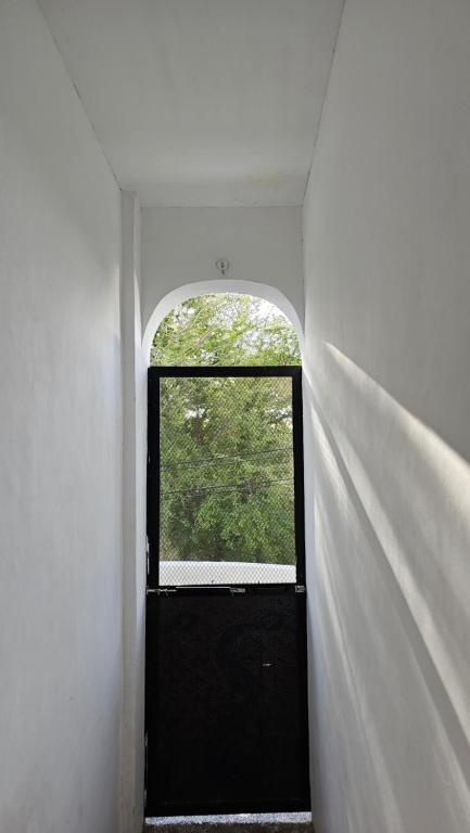 a hallway with a black door and a window at City Nest in Iloilo City