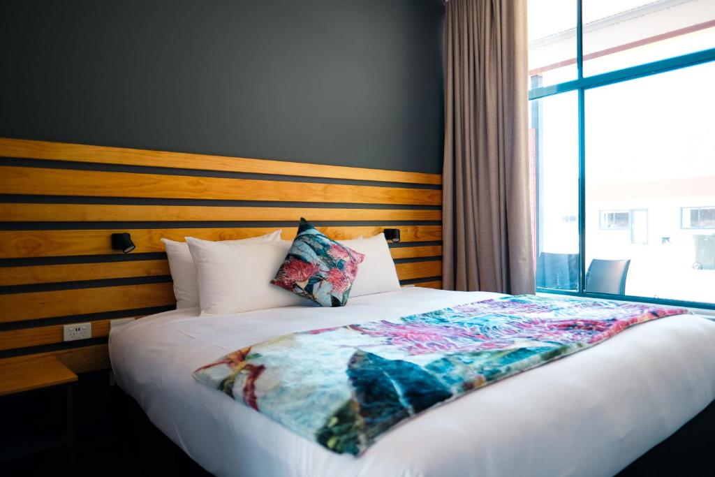 a bed in a room with a large window at Holbrook Motel in Holbrook