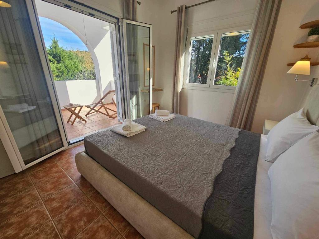 a bedroom with a large bed and a balcony at The hidden villas in Kolios