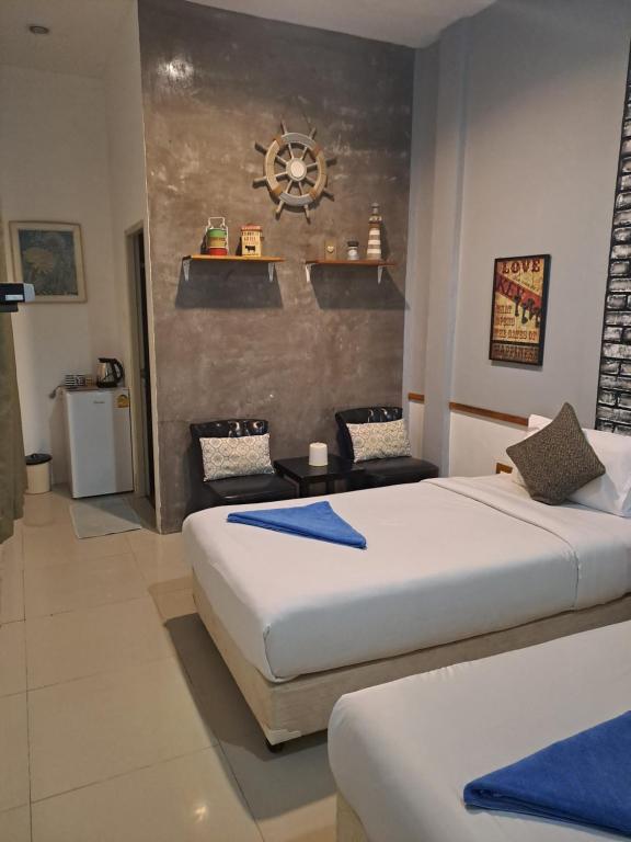 sypialnia z 2 łóżkami i zegarem na ścianie w obiekcie Baan Minnie w mieście Ko Samet